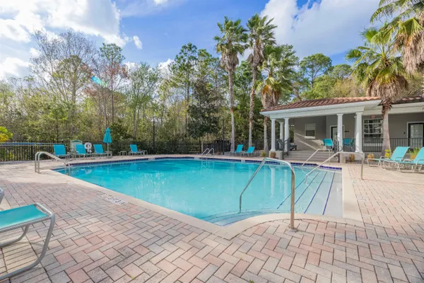 a view of a house with pool and chairs