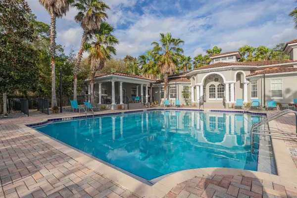 a view of a house with a yard and palm trees