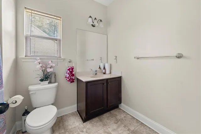 a bathroom with a sink vanity mirror and toilet