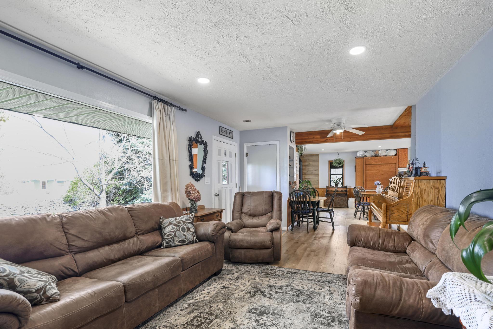 19591 Queen Crown Road Carey, ID 83320 - Photo 3 of 37 Spacious living area featuring large windows, recessed lighting, and wood-finish flooring