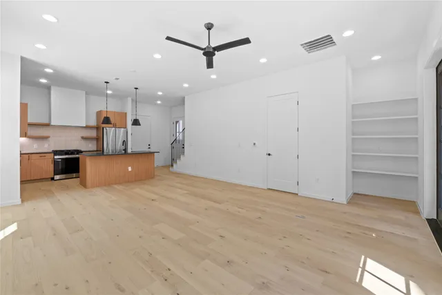 a view of a kitchen with kitchen island wooden floor and a ceiling fan