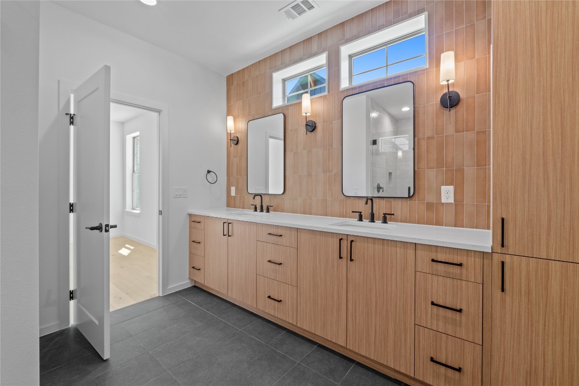 3500 Pecan Springs Road, Unit 16 Austin, TX 78723 - Photo 9 of 18 a spacious bathroom with a double vanity sink a large mirror and shower
