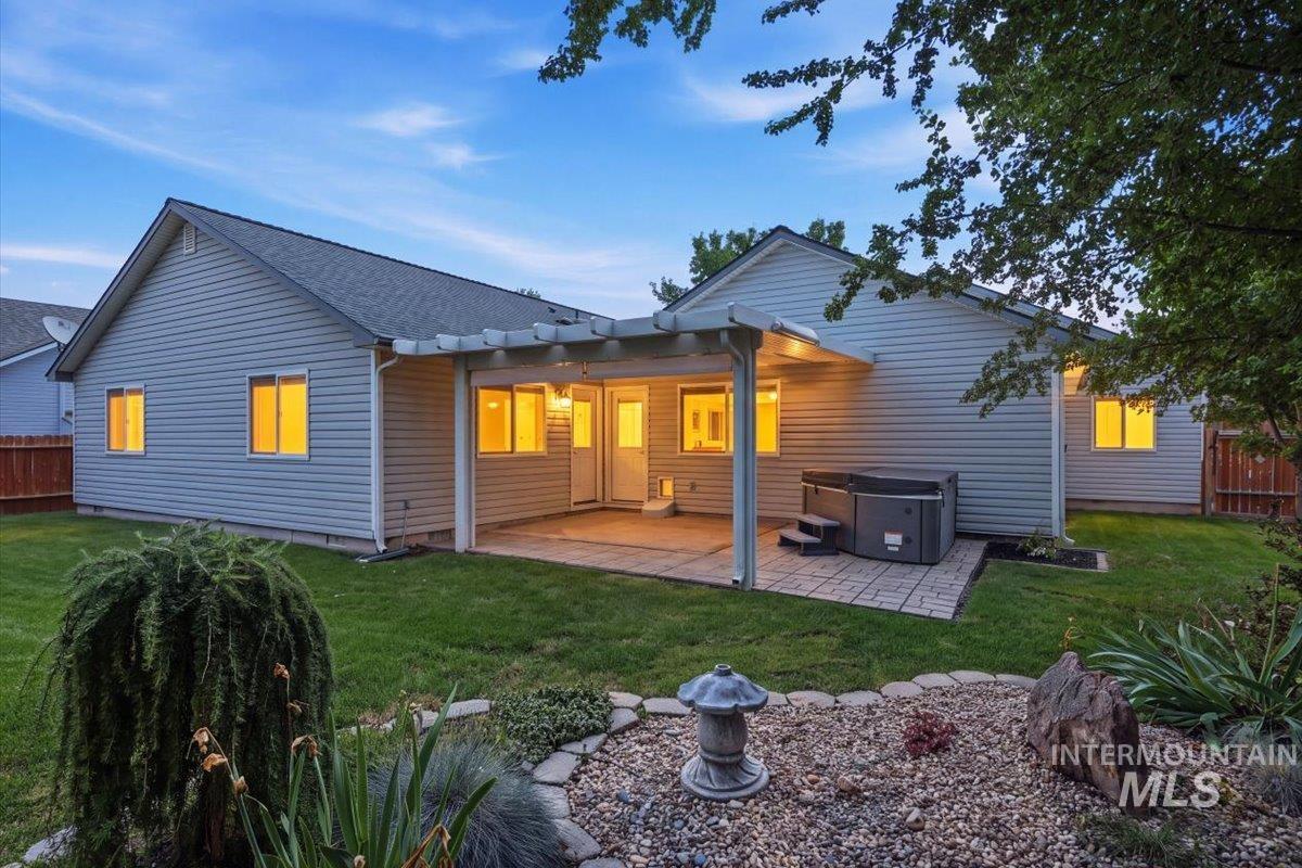 2075 North Springland Place Boise, ID 83713 - Photo 2 of 49 Expansive backyard featuring a covered patio, a hot tub, a manicured lawn, and a decorative rock garden