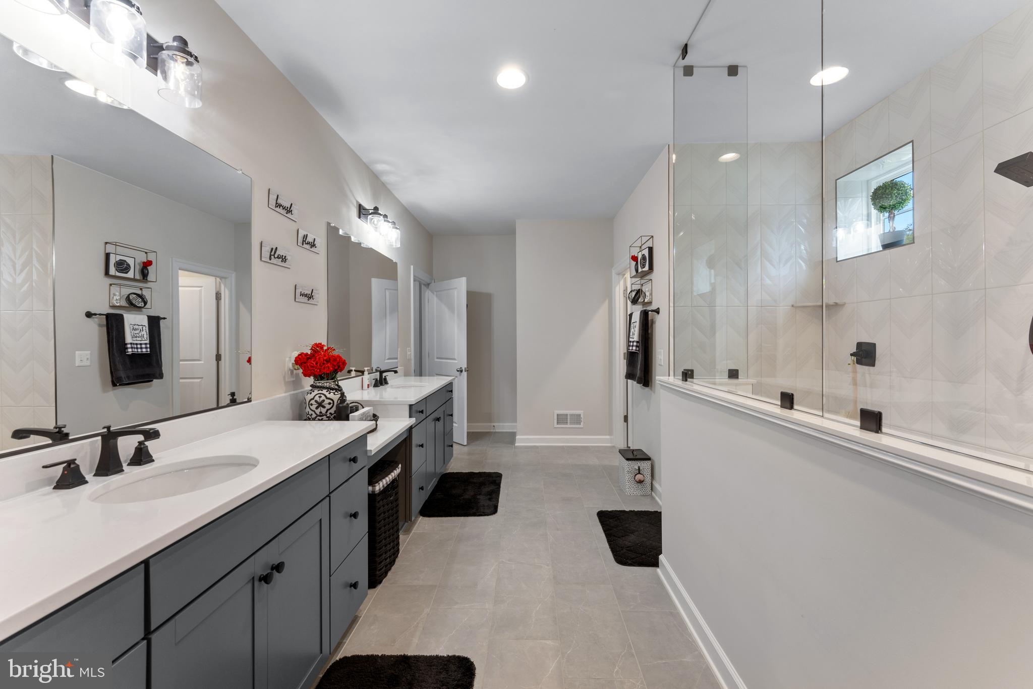 13882 Trinity Pond Lane Manassas, VA 20112 - Photo 45 of 69 a bathroom with a double vanity sink a mirror a shower and a bathtub
