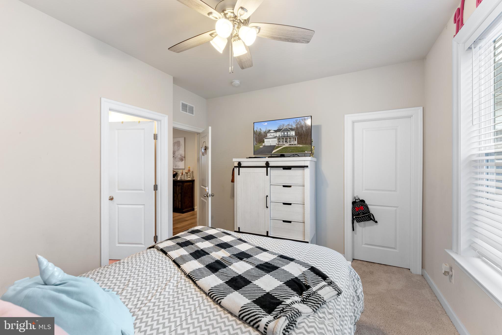 13882 Trinity Pond Lane Manassas, VA 20112 - Photo 50 of 69 a bedroom with a bed and a chandelier