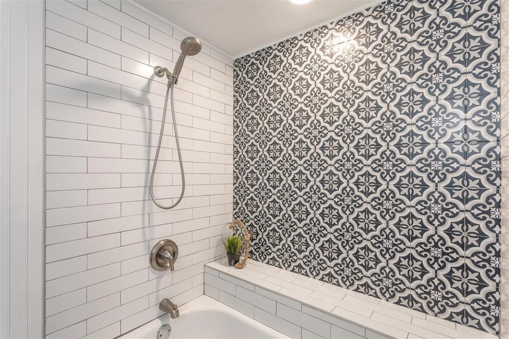 16301 Ledgemont Lane, Unit 283 Addison, TX 75001 - Photo 12 of 16 Tub/shower combo with blue accent textured tile wall and white subway tiles.