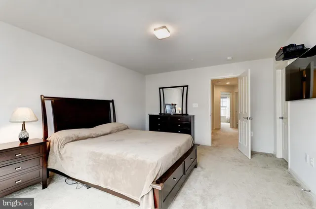 a large bedroom with a bed and flat tv