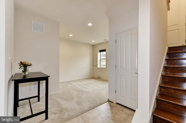 a view of a hallway to a livingroom with wooden floor and entryway