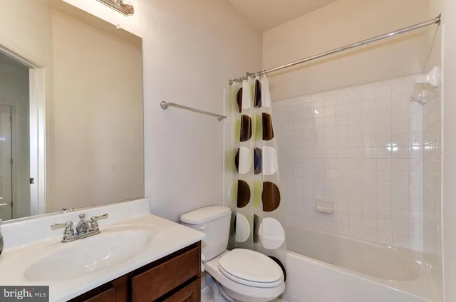 a bathroom with a sink a toilet a mirror and shower