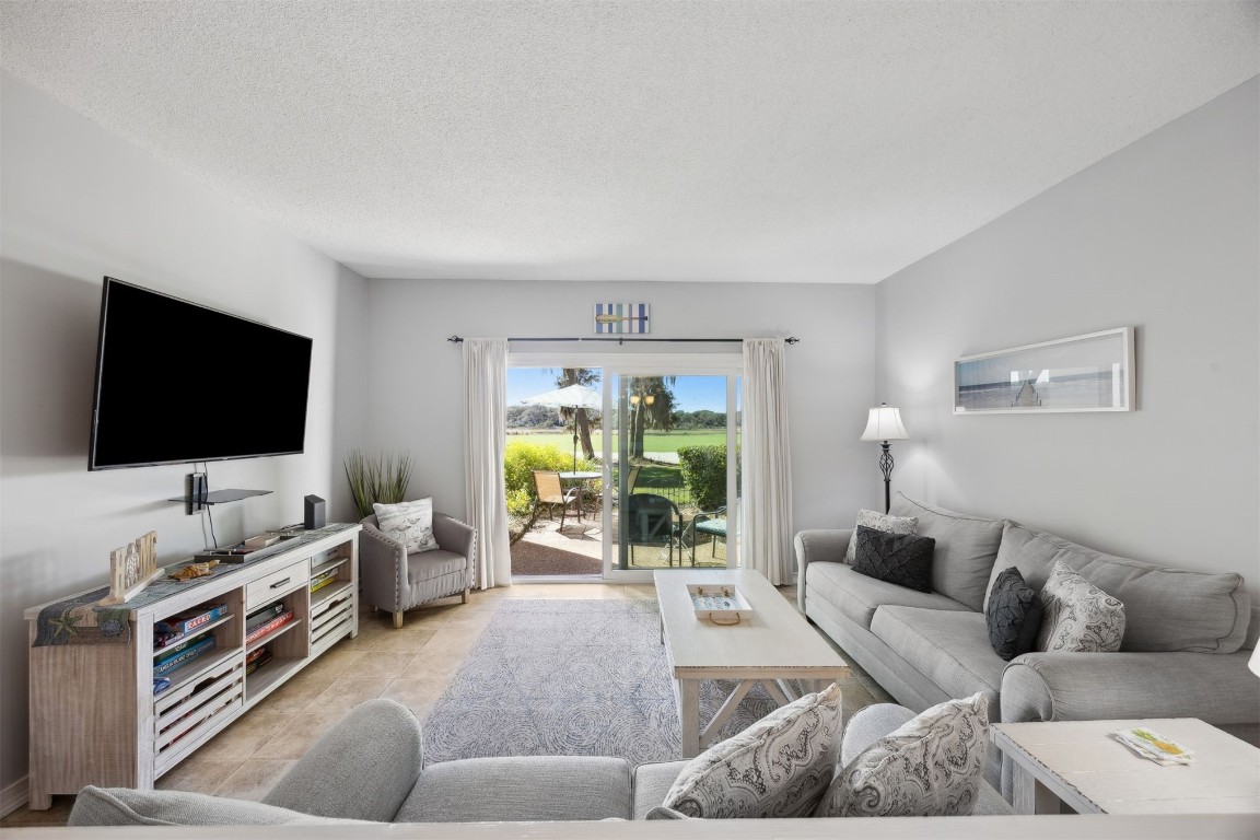 3012 Sea Marsh Road, Unit 3012 Fernandina Beach, FL 32034 - Photo 13 of 54 a living room with furniture and a flat screen tv