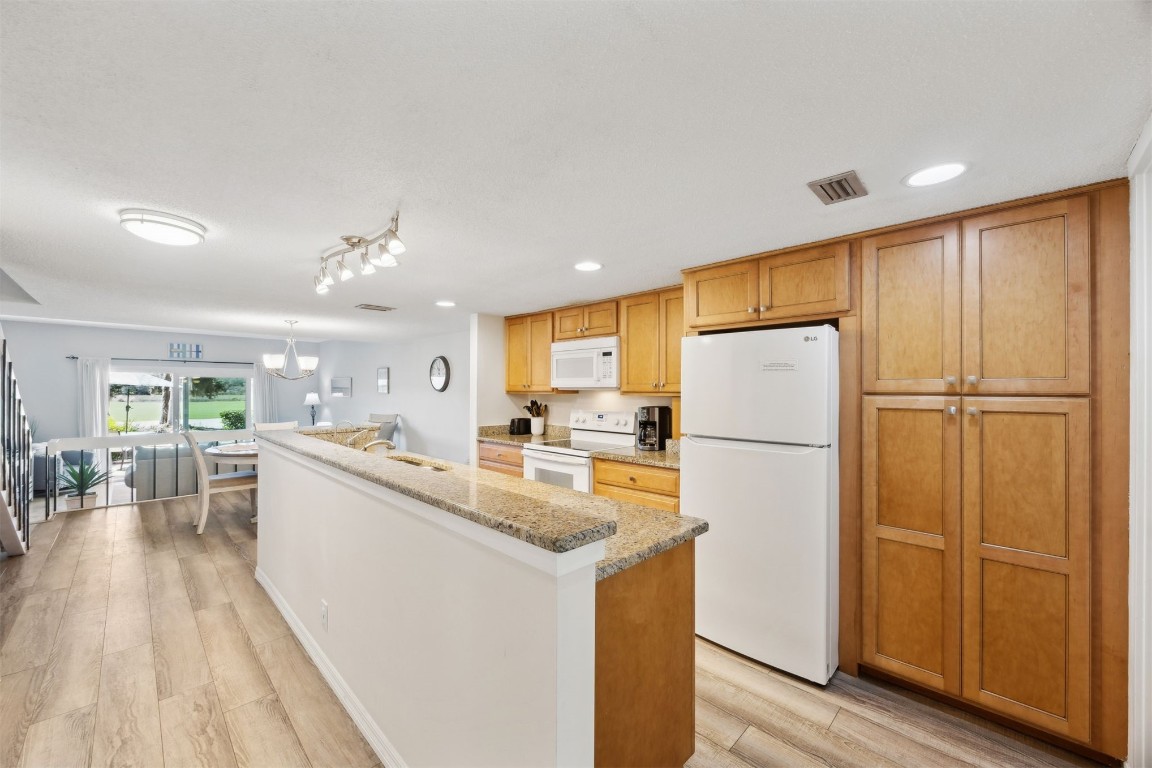 3012 Sea Marsh Road, Unit 3012 Fernandina Beach, FL 32034 - Photo 18 of 54 a kitchen with sink a refrigerator and wooden floor