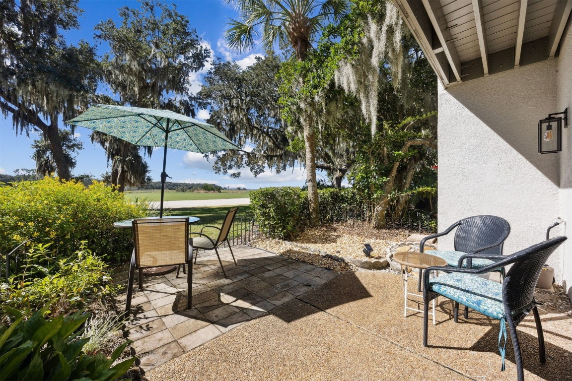 3012 Sea Marsh Road, Unit 3012 Fernandina Beach, FL 32034 - Photo 37 of 54 a view of a backyard with furniture and table under an umbrella with wooden fence
