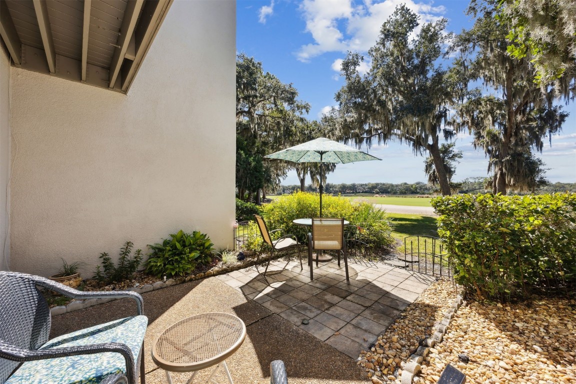 3012 Sea Marsh Road, Unit 3012 Fernandina Beach, FL 32034 - Photo 38 of 54 a view of a patio with table and chairs potted plants with wooden fence