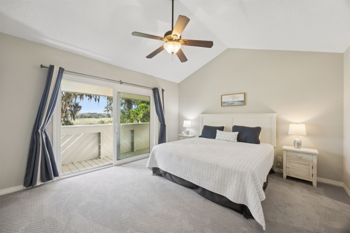 3012 Sea Marsh Road, Unit 3012 Fernandina Beach, FL 32034 - Photo 8 of 54 a bedroom with a large bed and a chandelier