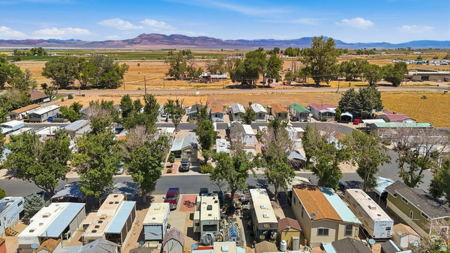 416 Kari Parowan, UT 84761 - Photo 7 of 14 Expansive property featuring numerous mobile homes, mature trees, paved roadways, and mountain scenery in the distance