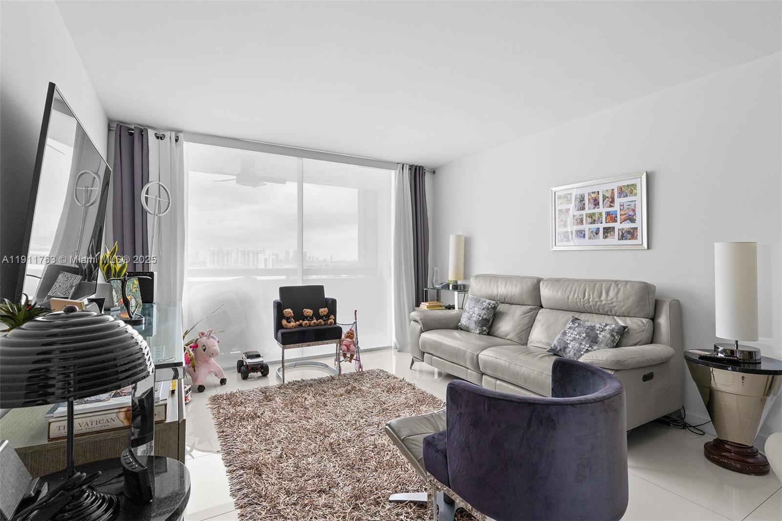 1775 Washington Avenue, Unit 14F Miami Beach, FL 33139 - Photo 4 of 25 a living room with furniture and a flat screen tv