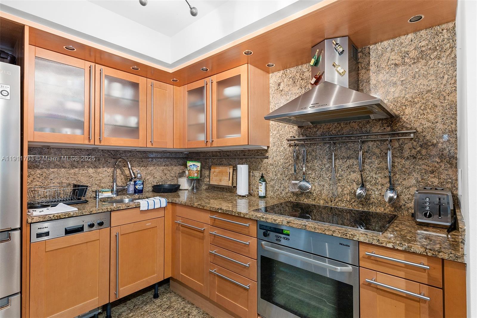 1775 Washington Avenue, Unit 14F Miami Beach, FL 33139 - Photo 8 of 25 a kitchen with stainless steel appliances granite countertop a sink a stove and cabinets