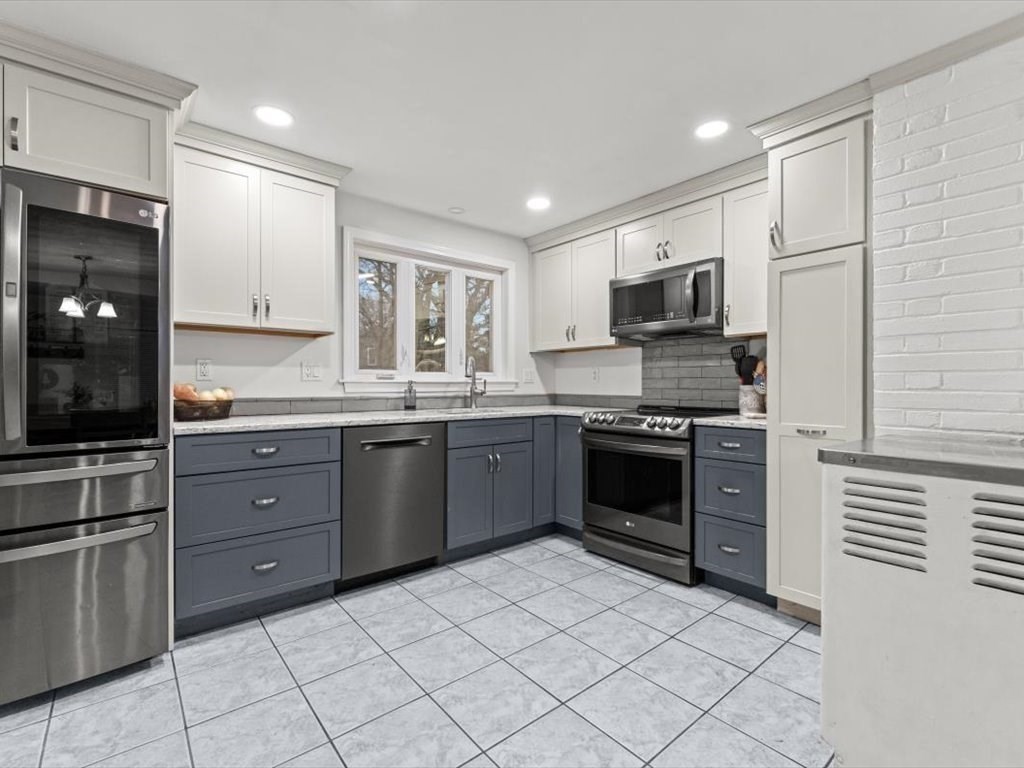 15 Rosslare Road Framingham, MA 01701 - Photo 9 of 37 a kitchen with stainless steel appliances granite countertop a stove a sink and a refrigerator