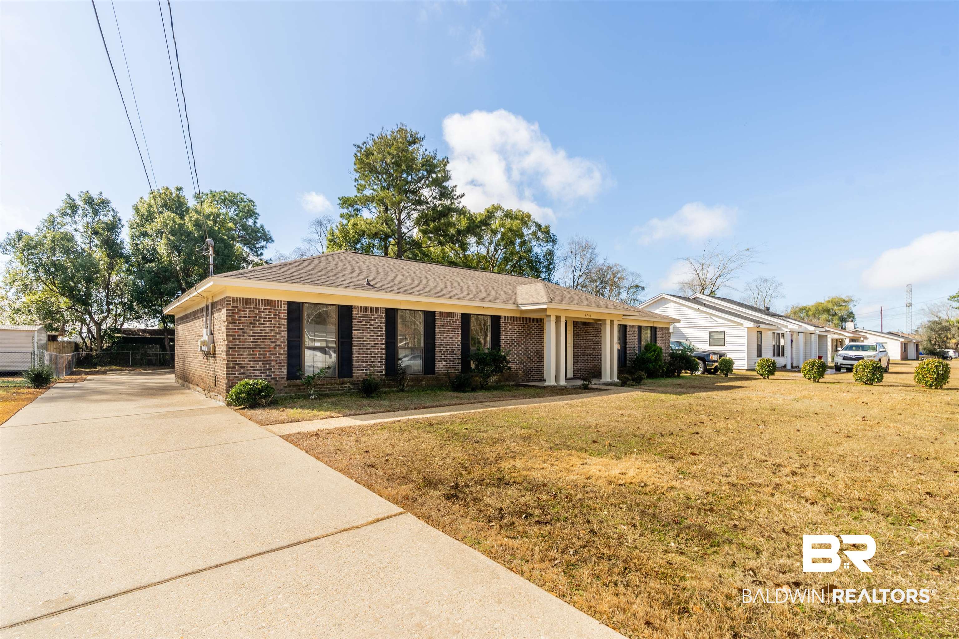 9751 Pine Knoll Road Mobile, AL 36608 - Photo 2 of 36 Ranch-style house with brick siding, a front yard, concrete driveway, and a shingled roof