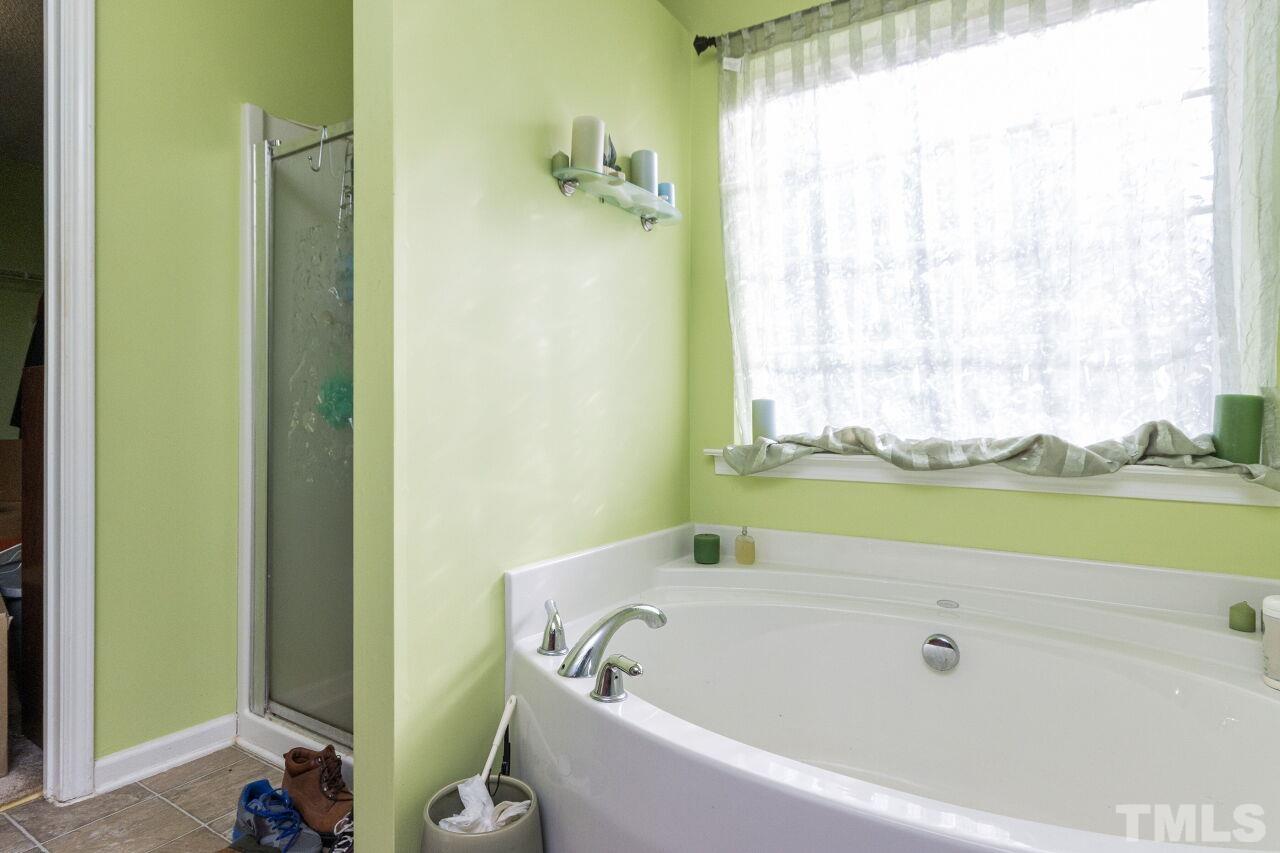 6122 Ricker Road Raleigh, NC 27610 - Photo 15 of 20 a bathroom with bathtub and window