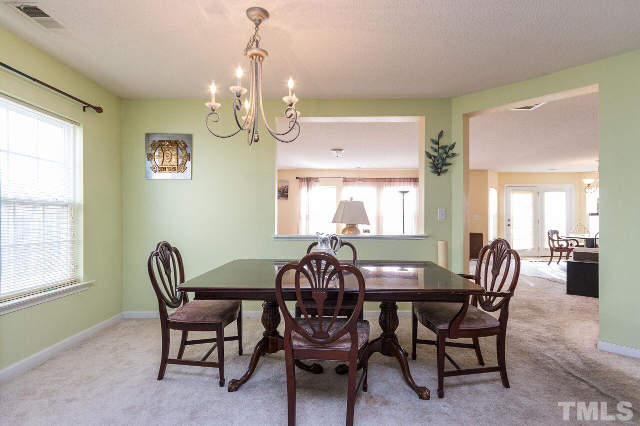 6122 Ricker Road Raleigh, NC 27610 - Photo 5 of 20 a view of a dining room with furniture and chandelier
