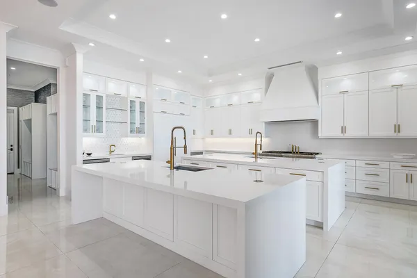 a kitchen with stainless steel appliances sink stove and white cabinets