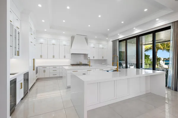 a large white kitchen with a large window