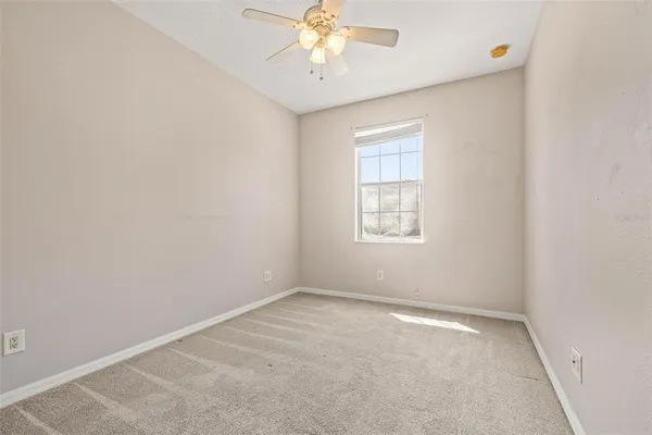 an empty room with a window and a ceiling fan