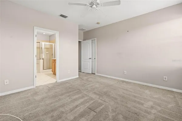 a view of an empty room with a ceiling fan