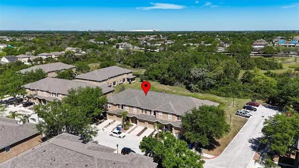 an aerial view of residential houses with outdoor space and trees