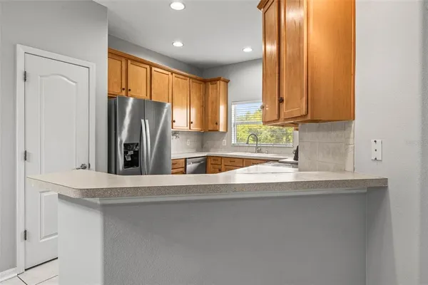 a view of a kitchen with a sink a refrigerator and window