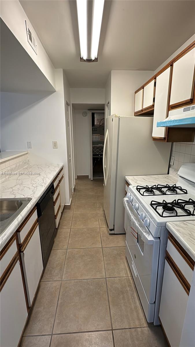 15320 Southwest 106th Terrace, Unit 1118 Miami, FL 33196 - Photo 4 of 25 a kitchen with a stove top oven and refrigerator