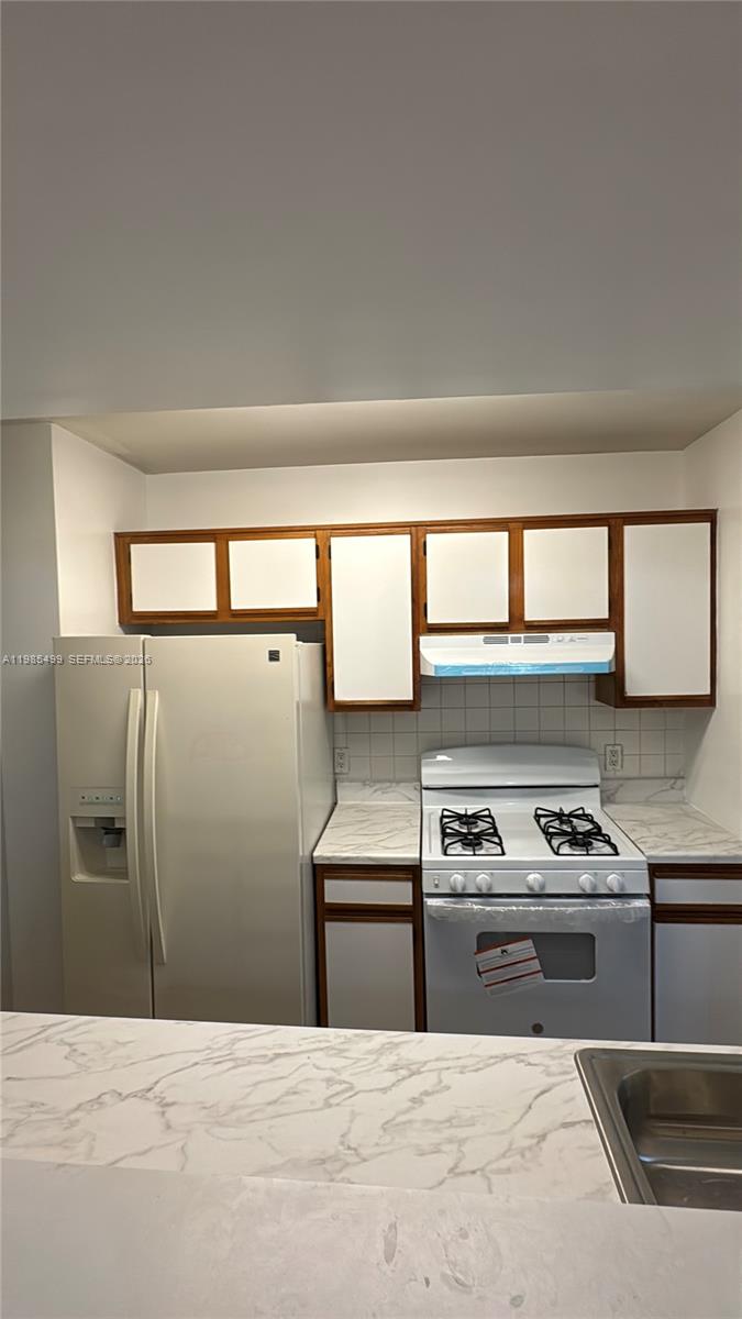 15320 Southwest 106th Terrace, Unit 1118 Miami, FL 33196 - Photo 7 of 25 a kitchen with a refrigerator and a sink