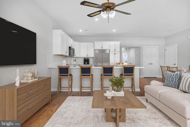 a living room with furniture kitchen view and a flat screen tv
