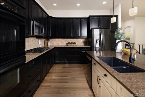 a kitchen with granite countertop a refrigerator and a sink