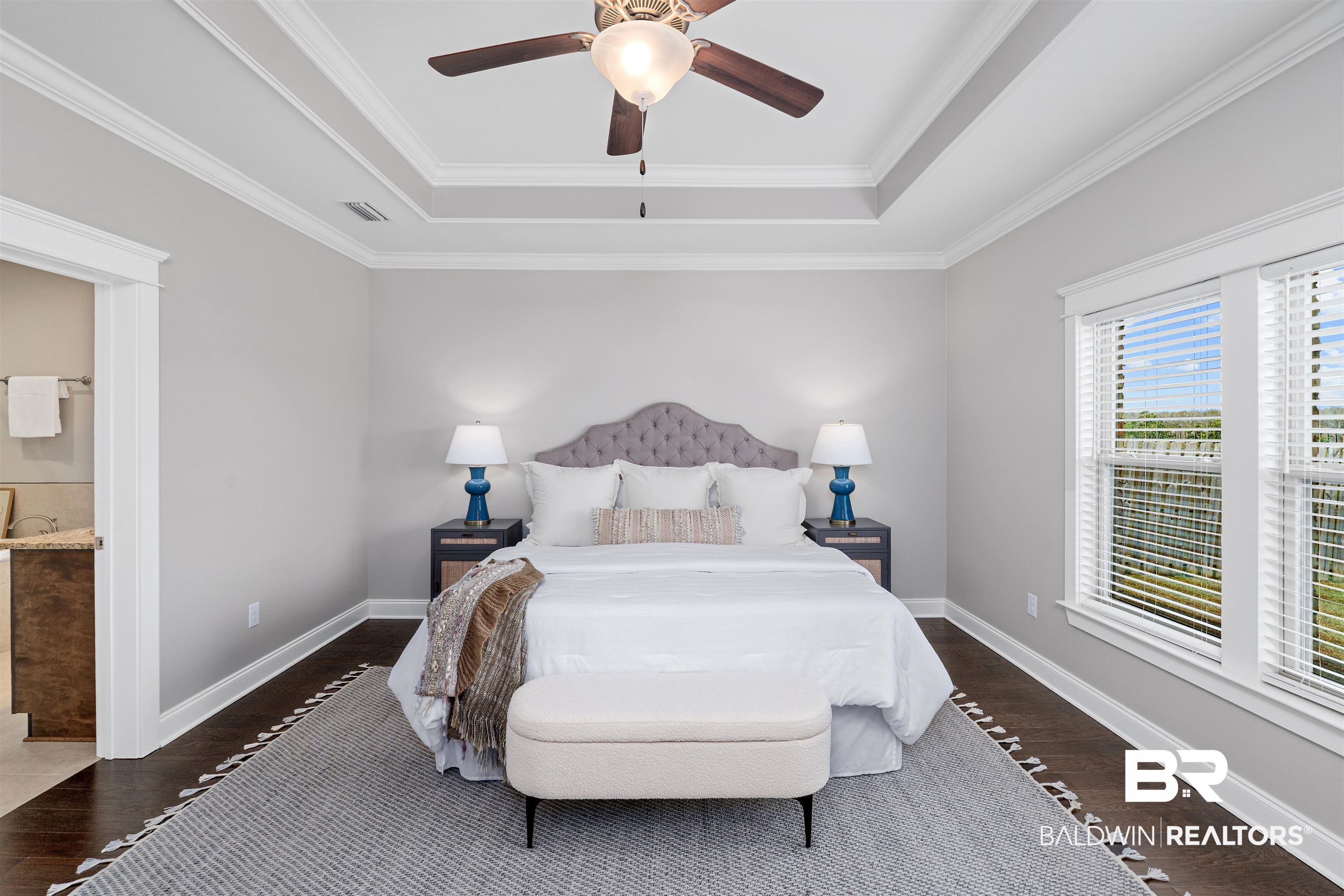 24838 Slater Mill Road Daphne, AL 36526 - Photo 31 of 46 Bedroom featuring a tray ceiling, dark wood finished floors, ornamental molding, ceiling fan, and ensuite bath