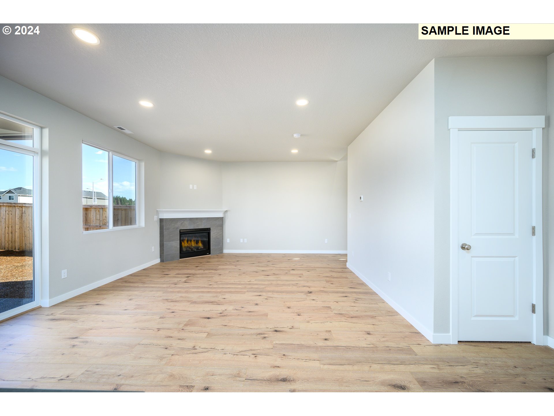 10572 Southeast Heritage Road, Unit 308 Happy Valley, OR 97086 - Photo 4 of 22 a view of an empty room with wooden floor and a window