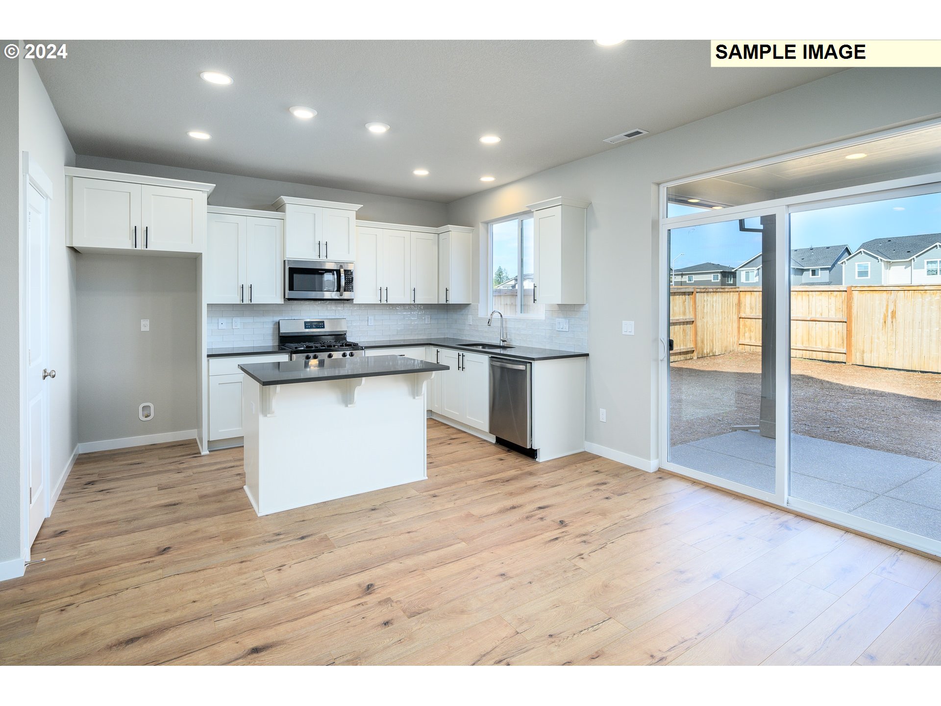 10572 Southeast Heritage Road, Unit 308 Happy Valley, OR 97086 - Photo 7 of 22 a kitchen with stainless steel appliances granite countertop a stove top oven a sink and a refrigerator