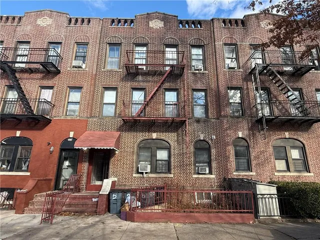 a front view of a residential apartment building with a yard