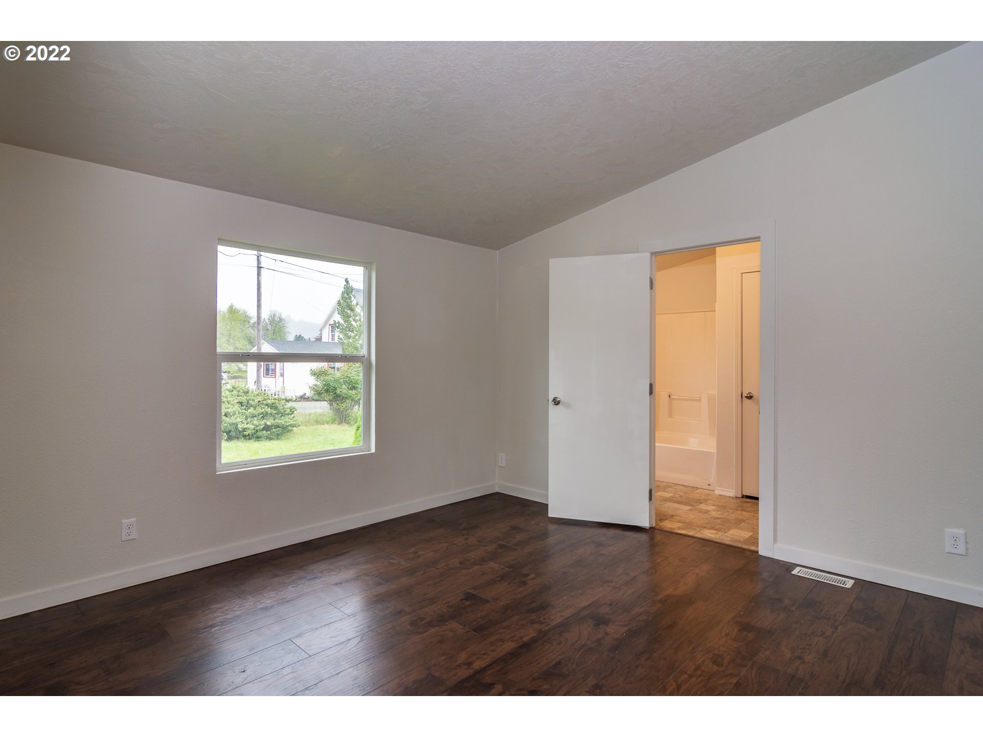 692 Mathis Hill Road Yoncalla, OR 97499 - Photo 16 of 31 a view of an empty room with wooden floor and a window
