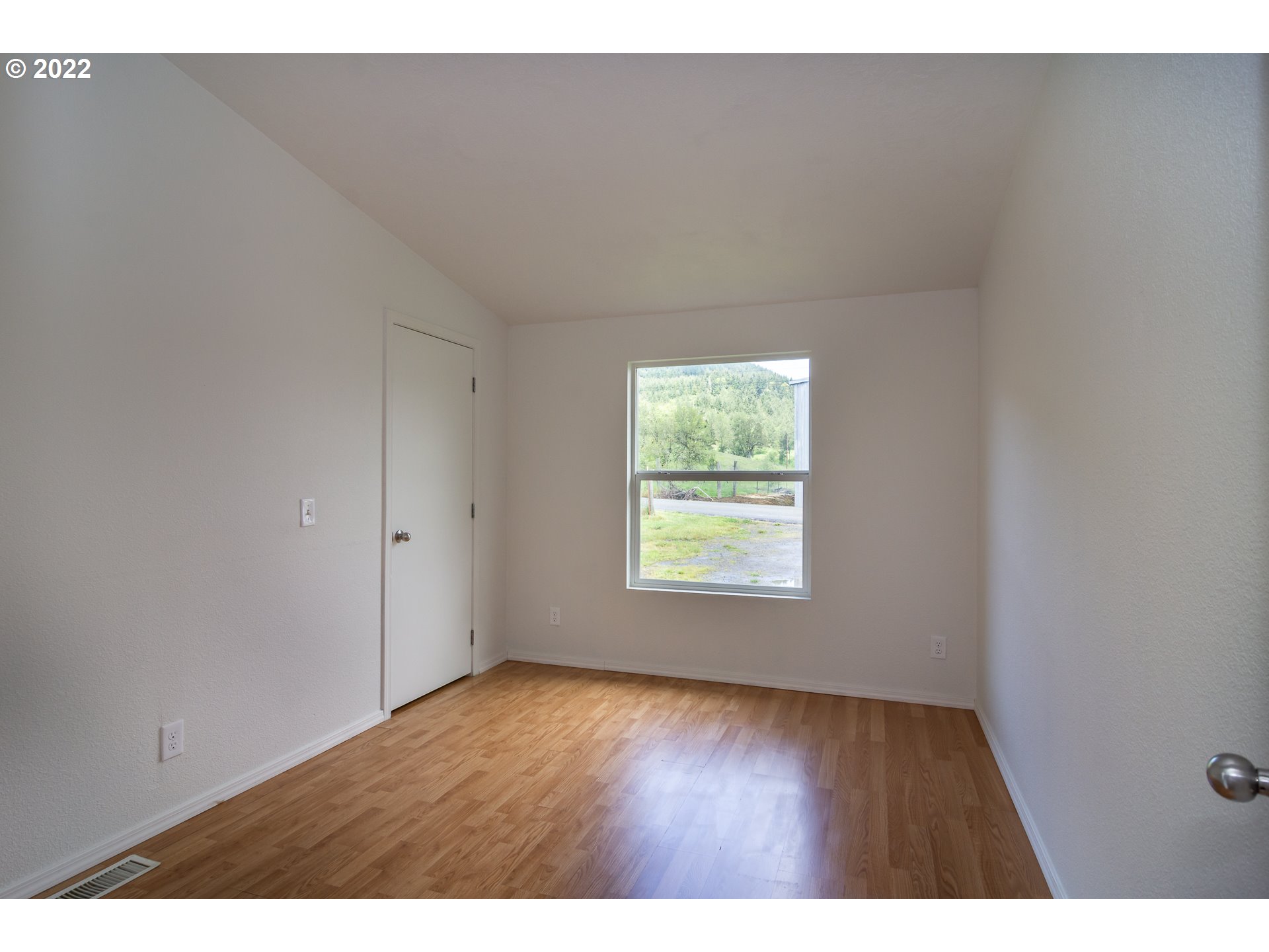 692 Mathis Hill Road Yoncalla, OR 97499 - Photo 24 of 31 a view of an empty room with wooden floor and a window