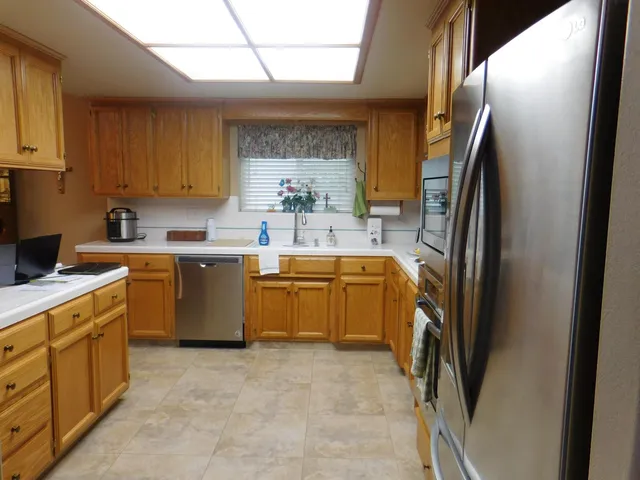 a kitchen with a sink refrigerator and cabinets