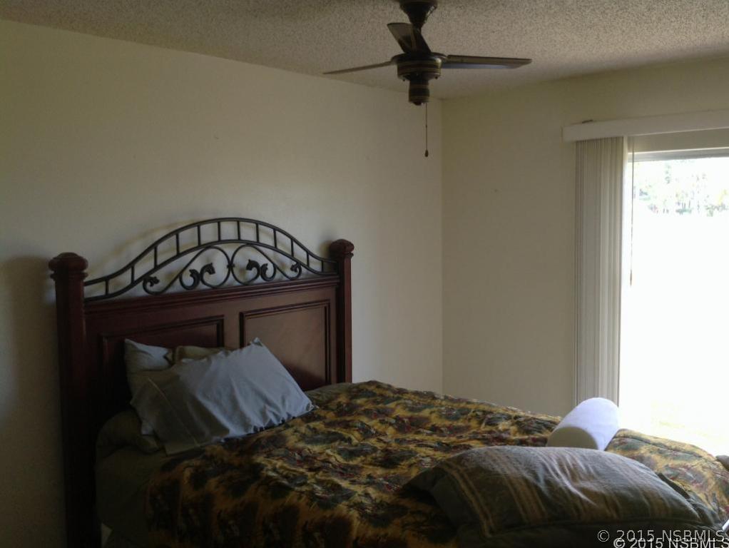 1307 South Riverside Drive Edgewater, FL 32132 - Photo 3 of 8 a bedroom with a bed and a tv
