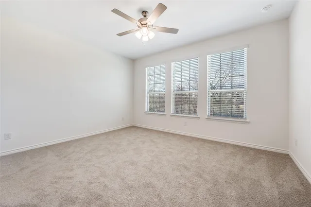 an empty room with chandelier fan