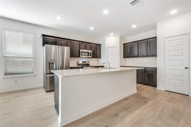 a kitchen with refrigerator cabinets and microwave