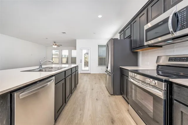 a kitchen with stainless steel appliances granite countertop a stove a sink dishwasher and a refrigerator