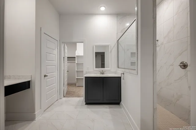 a bathroom with a shower sink and mirror