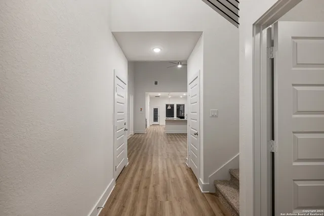 a view of a hallway with wooden floor and staircase