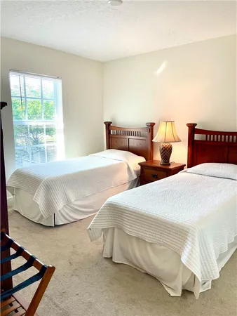 a bedroom with two beds and a large window