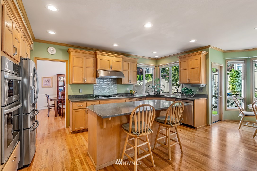 3009 214th Street Southeast Bothell, WA 98021 - Photo 15 of 36 a kitchen with stainless steel appliances granite countertop a stove and a wooden floors
